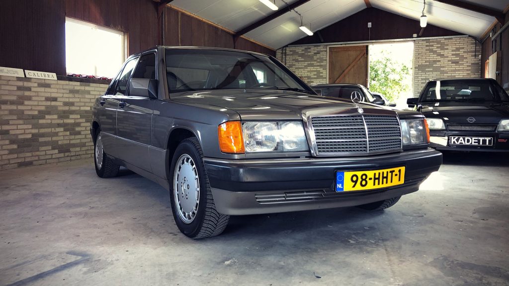 Mercedes-Benz 190 E 2.3, driekwart van voren tegen een donkere gevel