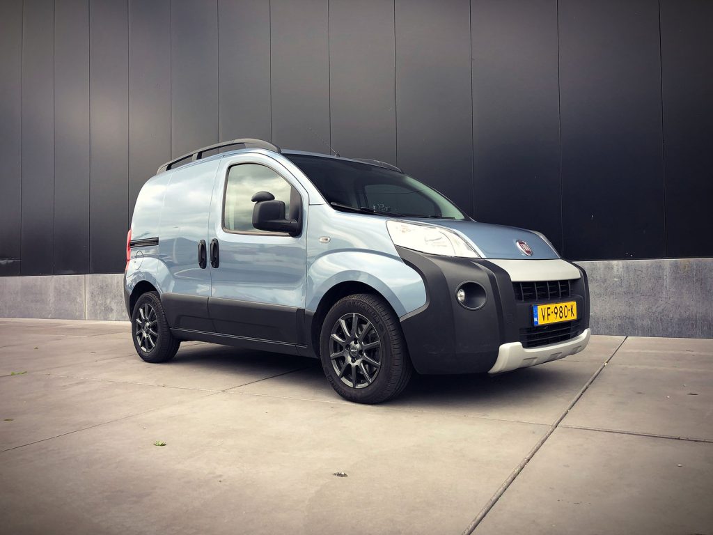 Fiat Fiorino 1.3 MultiJet 16v (95pk) Adventure, driekwart van voren tegen een donkere gevel