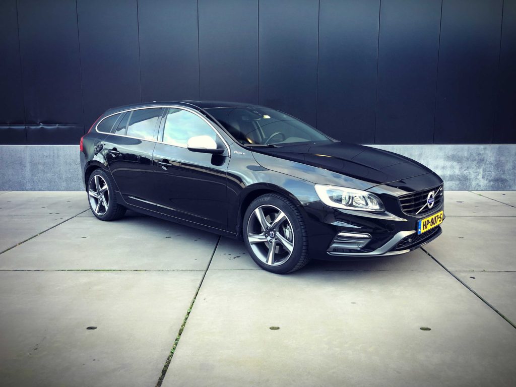Volvo V60 D6 Twin Engine R-Design, driekwart van voren tegen een donkere gevel