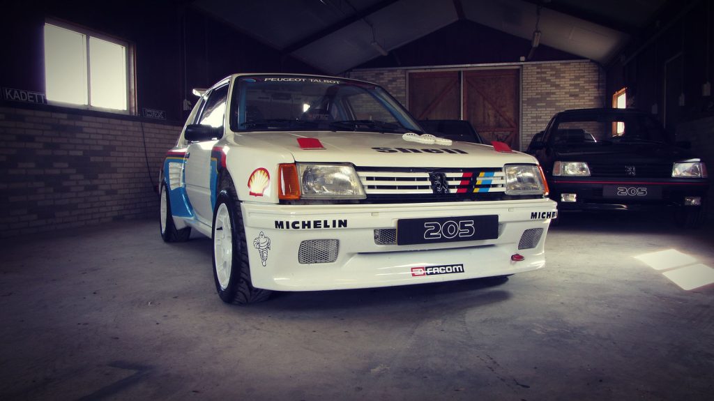 Peugeot 205 Rallye 1.6 Dimma T16, driekwart van voren tegen een donkere gevel