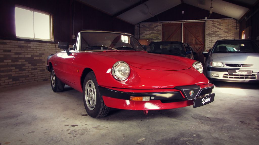 Alfa Romeo Spider 2.0, driekwart van voren tegen een donkere gevel