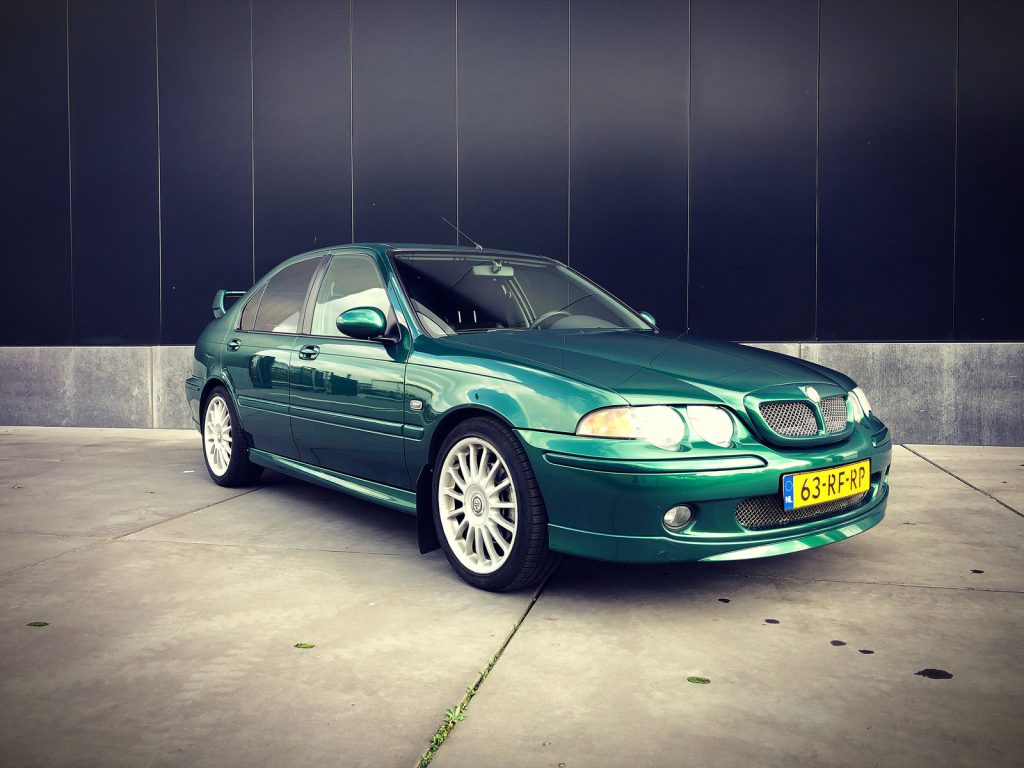 MG ZS 180, driekwart van voren tegen een donkere gevel