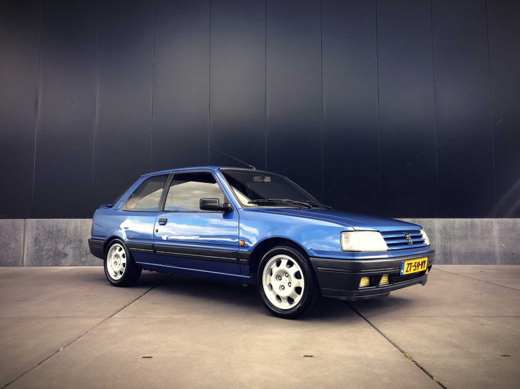 Peugeot 309 GTI 1.9 16 (160pk), driekwart van voren tegen een donkere gevel