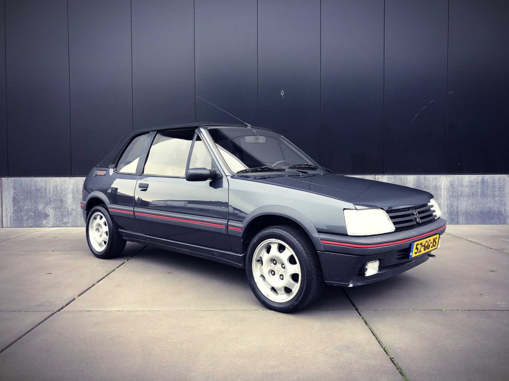 Peugeot 205 CTI 1.9, driekwart van voren tegen een donkere gevel