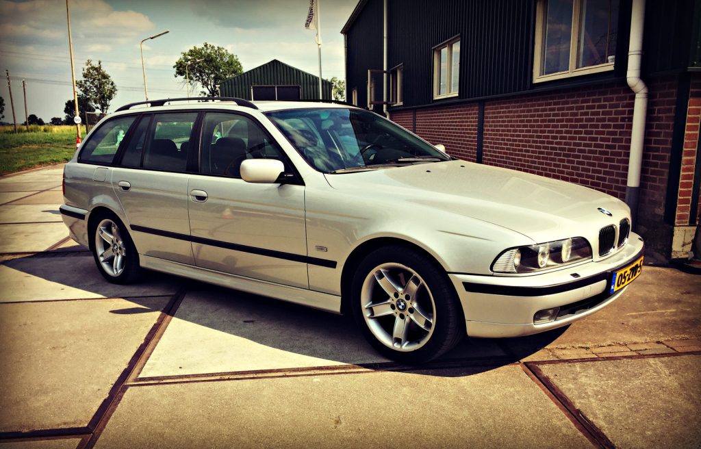 BMW 540i Touring (E39), driekwart van voren tegen een donkere gevel