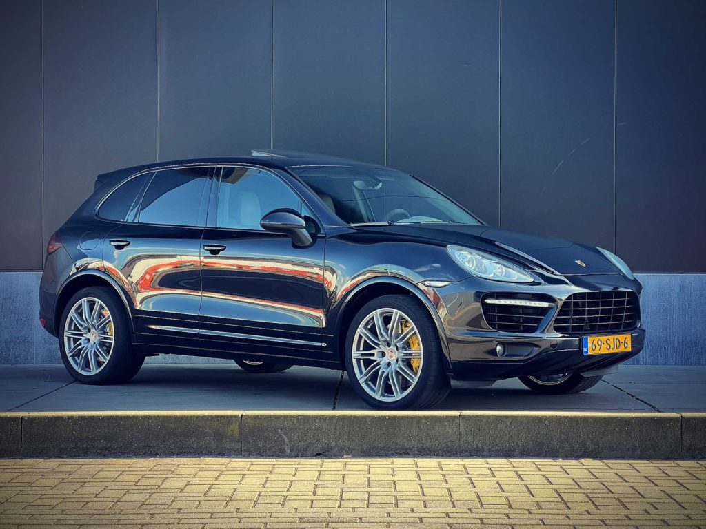 Porsche Cayenne Turbo, driekwart van voren tegen een donkere gevel