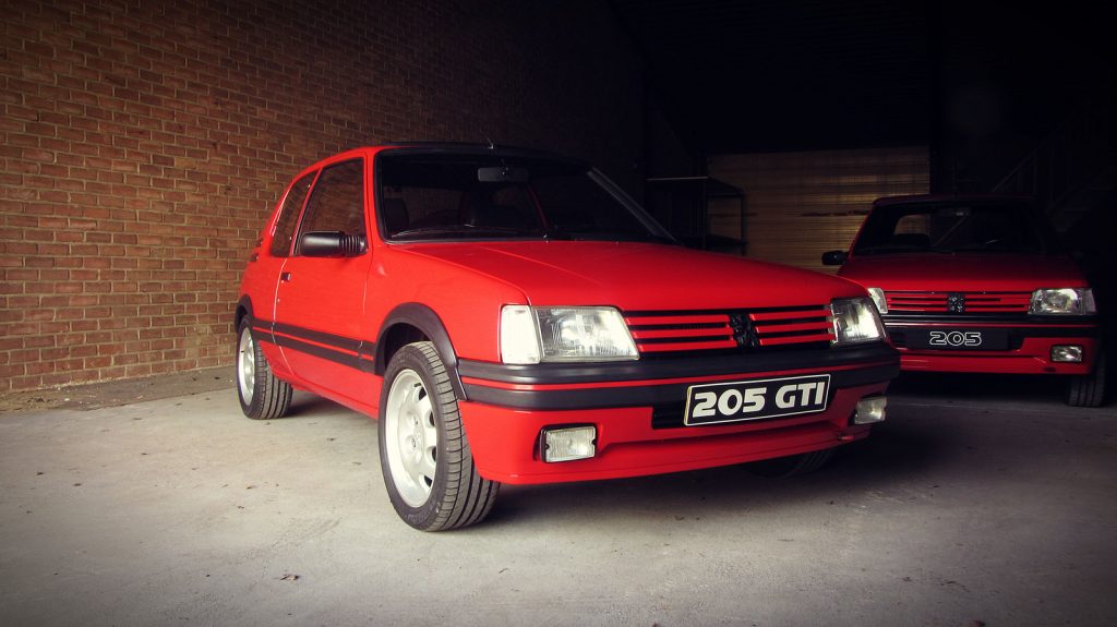 Peugeot 205 GTI 1.9, driekwart van voren tegen een donkere gevel