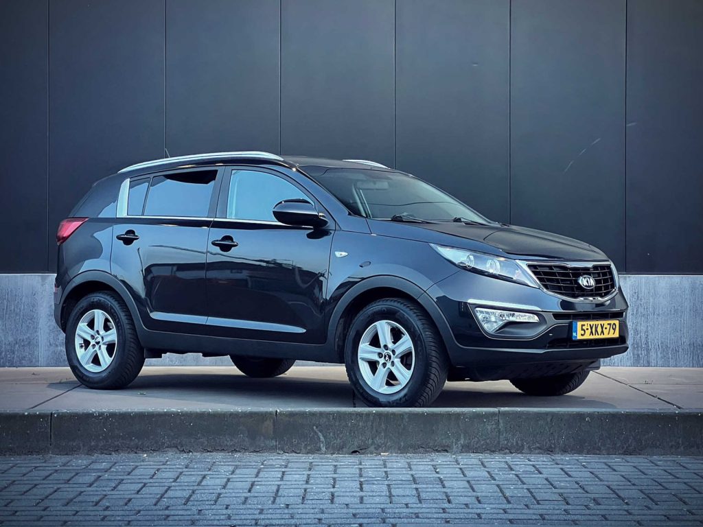 Kia Sportage 1.6 GDI ComfortLine, driekwart van voren tegen een donkere gevel