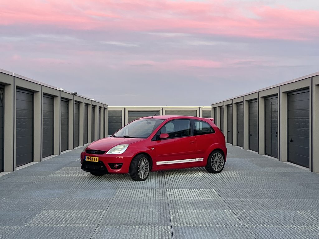 Ford Fiesta ST 2.0 16V in rood, driekwart van voren op een parkeerdak