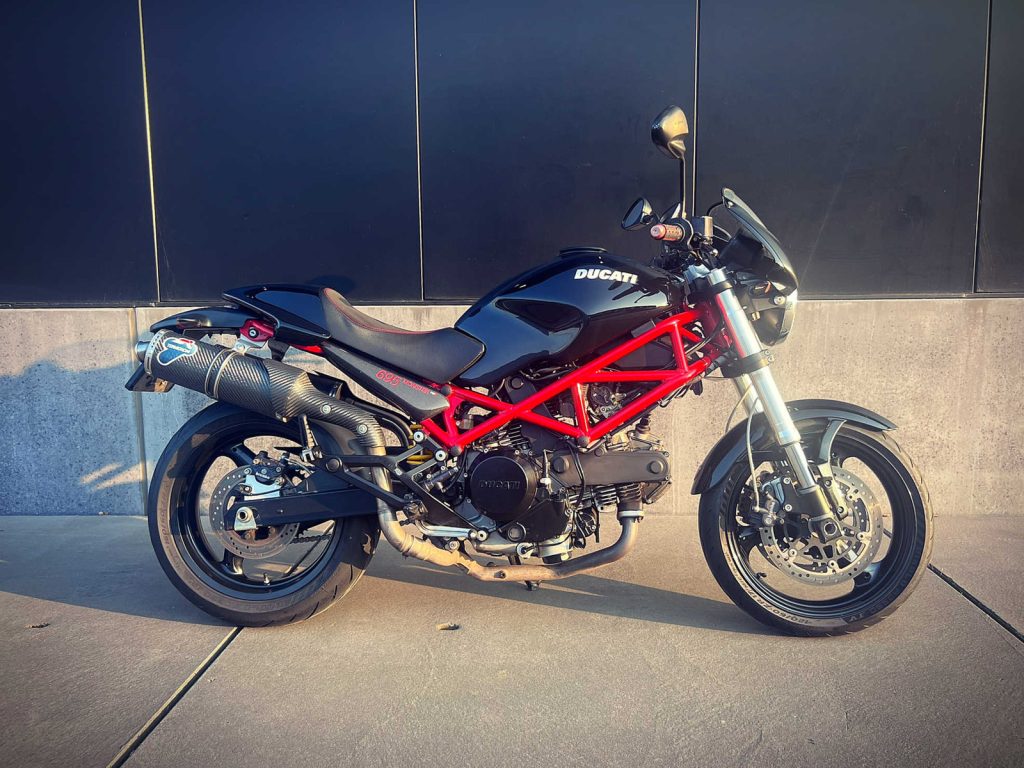Ducati Monster M695, driekwart van voren tegen een donkere gevel
