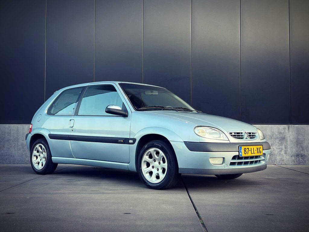 Citroën Saxo VTS 1.6, driekwart van voren tegen een donkere gevel