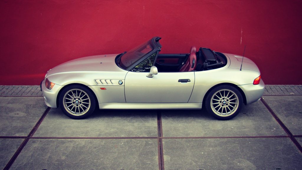 BMW Z3 1.8 Roadster (M-Sportfahrwerk), driekwart van voren tegen een donkere gevel