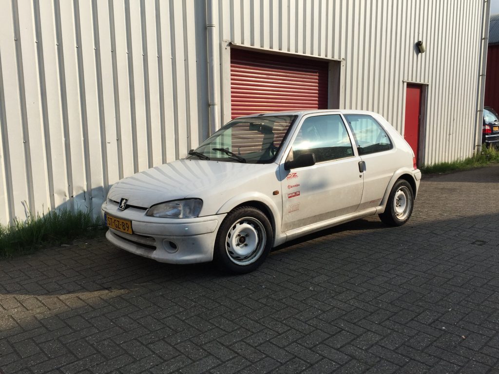 Peugeot 106 Rallye, driekwart van voren tegen een donkere gevel