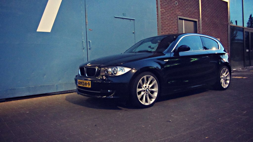 BMW 123d (E81), driekwart van voren tegen een donkere gevel