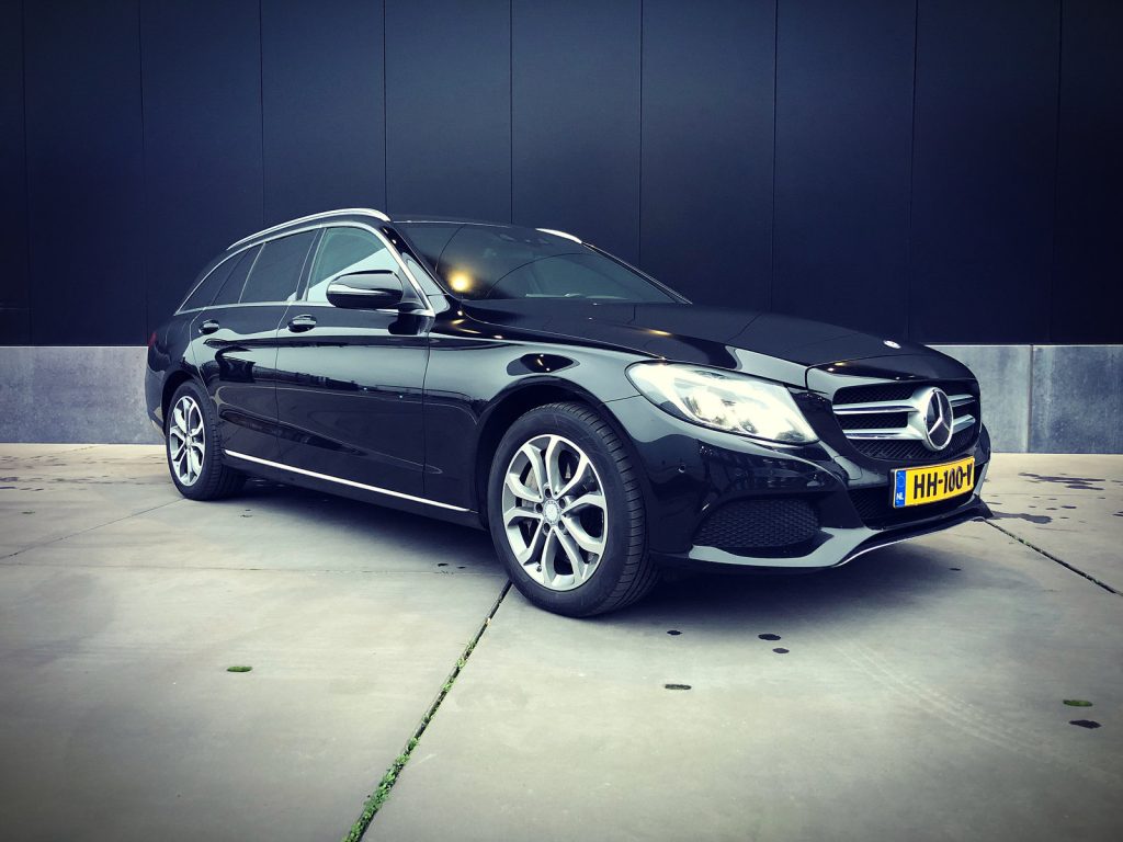 Mercedes-Benz C350e Hybrid Estate, driekwart van voren tegen een donkere gevel