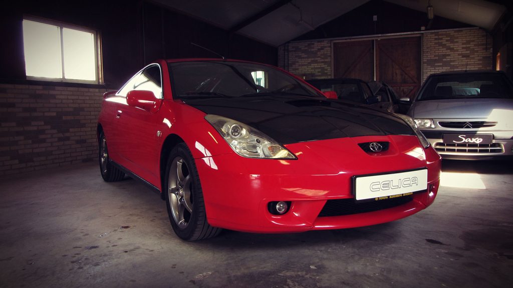 Toyota Celica 1.8 16v VVT-i (143pk), driekwart van voren tegen een donkere gevel