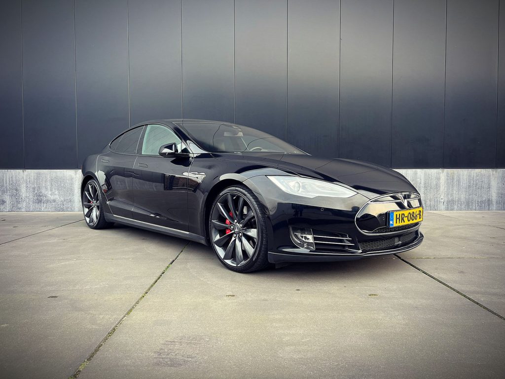 Tesla Model S 70D, driekwart van voren tegen een donkere gevel