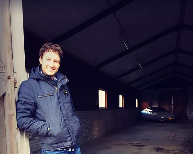 Juriaan Poot leunend in de deuropening van een schuur