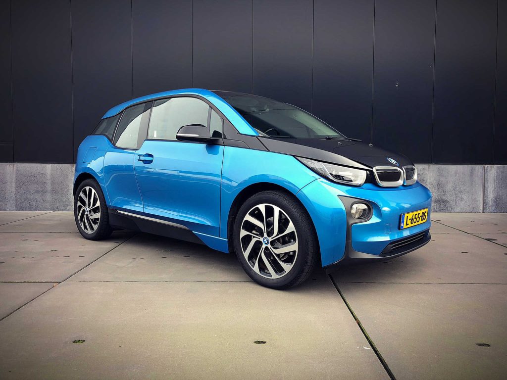 BMW i3 94Ah, driekwart van voren tegen een donkere gevel