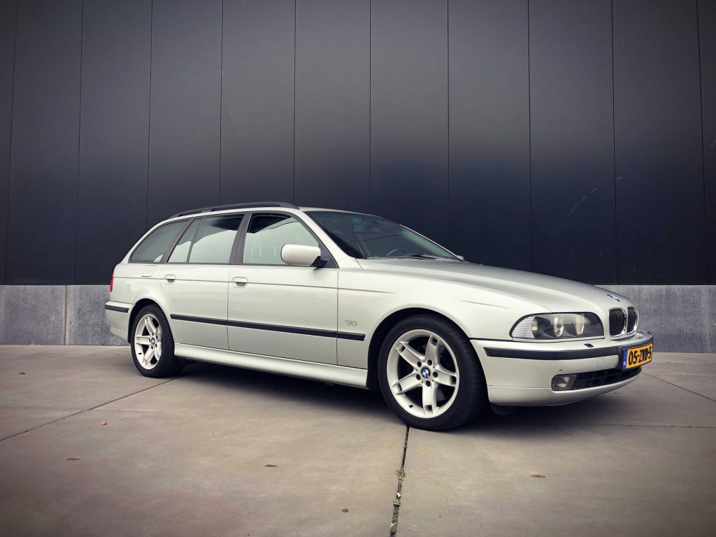 BMW 540i Touring (E39), driekwart van voren tegen een donkere gevel