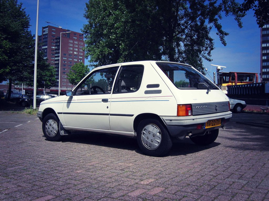 Peugeot 205 XL 1.1i, driekwart van voren tegen een donkere gevel