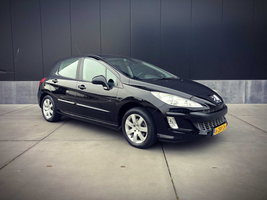 Peugeot 308 XS 1.6 VTi Aut., driekwart van voren tegen een donkere gevel